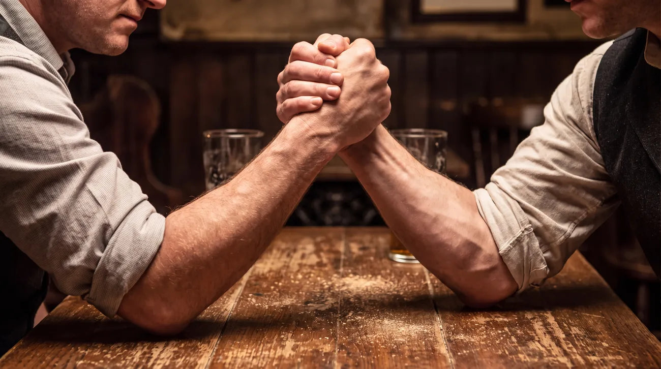 Two men arm wrestling on a pub table